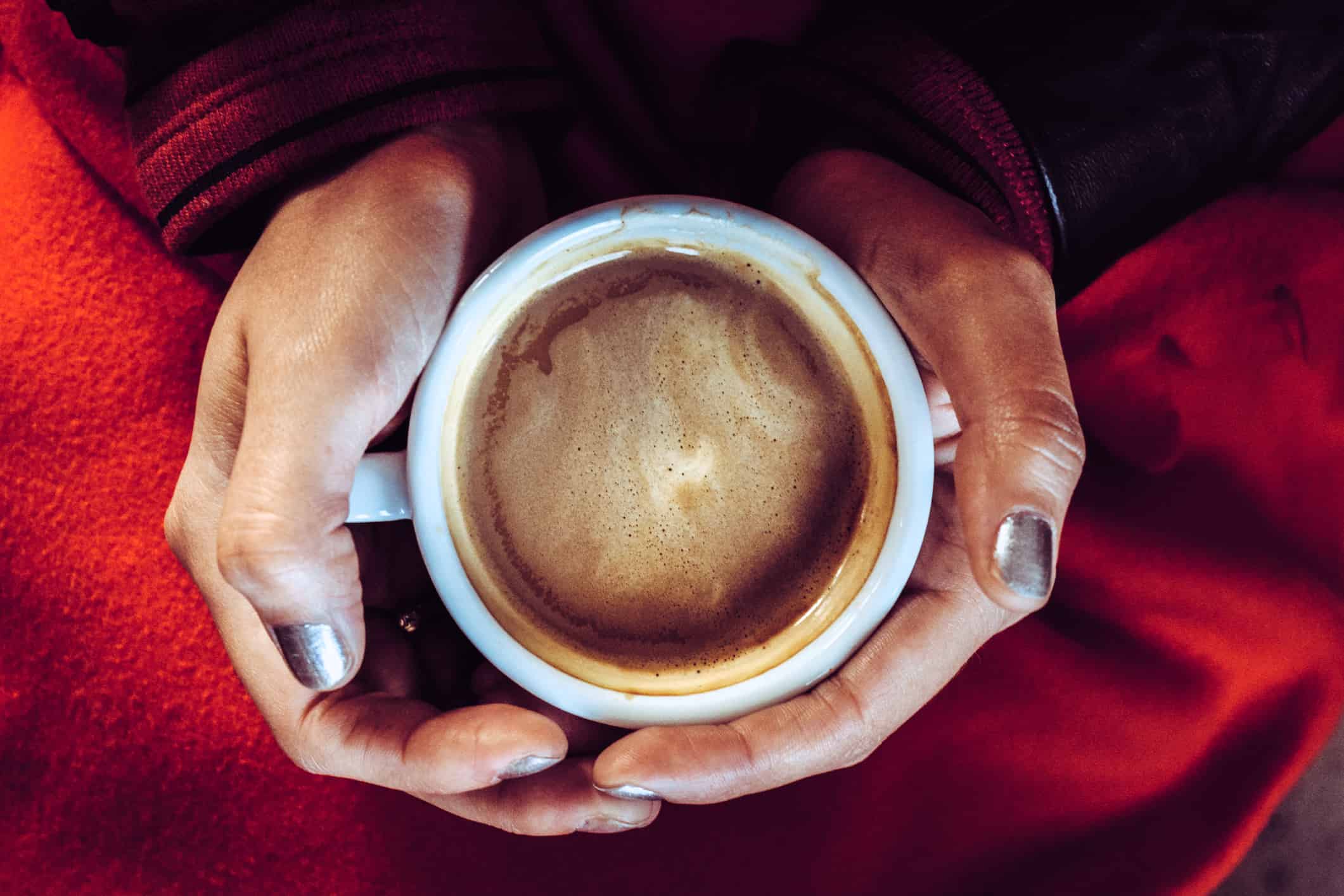 Una persona tomando una taza de mocaccino caliente.